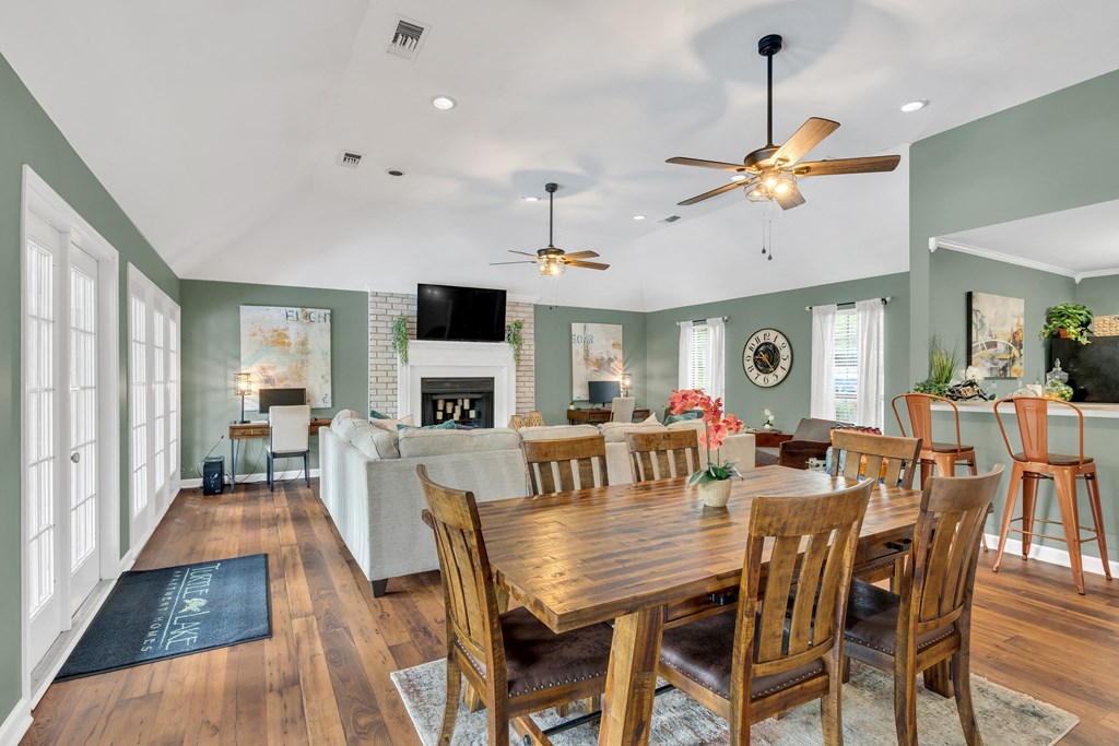 a living room with a dining room table and a fireplace